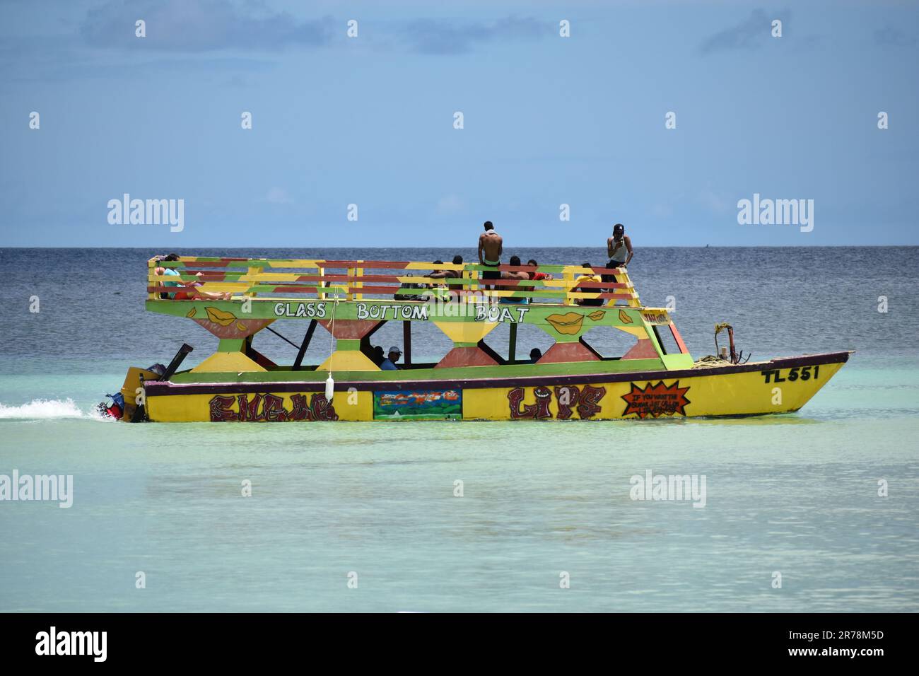 Barche con fondo in vetro a Pigeon Point che trasportano turisti in tour per vedere la barriera corallina di Buccoo, la piscina di Nylon e la Terra di No Man a Tobago. Foto Stock
