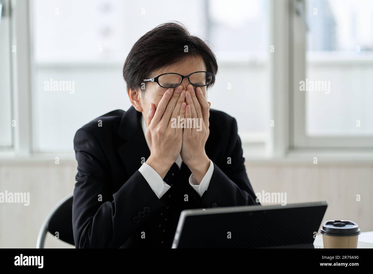 Uomo d'affari asiatico stanco al lavoro Foto Stock