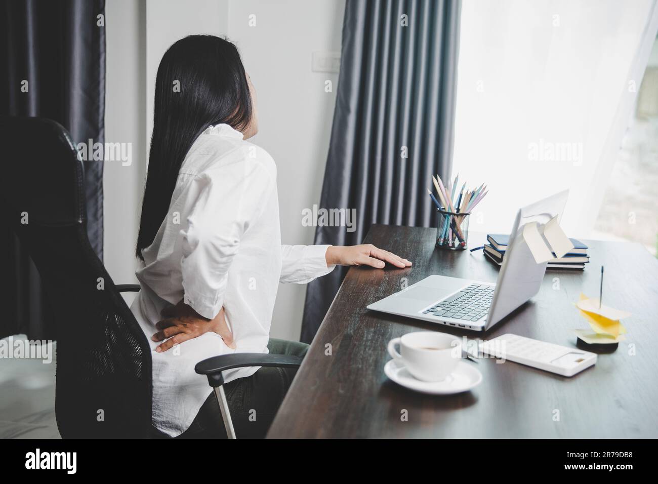 Giovane donna asiatica è seduta al lavoro e ha dolore di tensione al collo. Concetto ufficio sindrome mal di schiena dolore da malattie professionali, femmina avendo Foto Stock