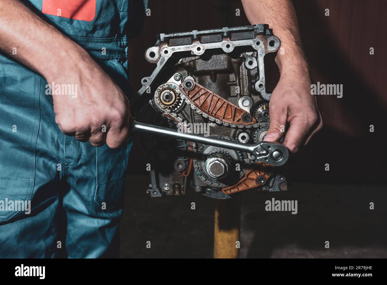 Meccanico auto con una chiave sta riparando un motore di automobile Foto Stock