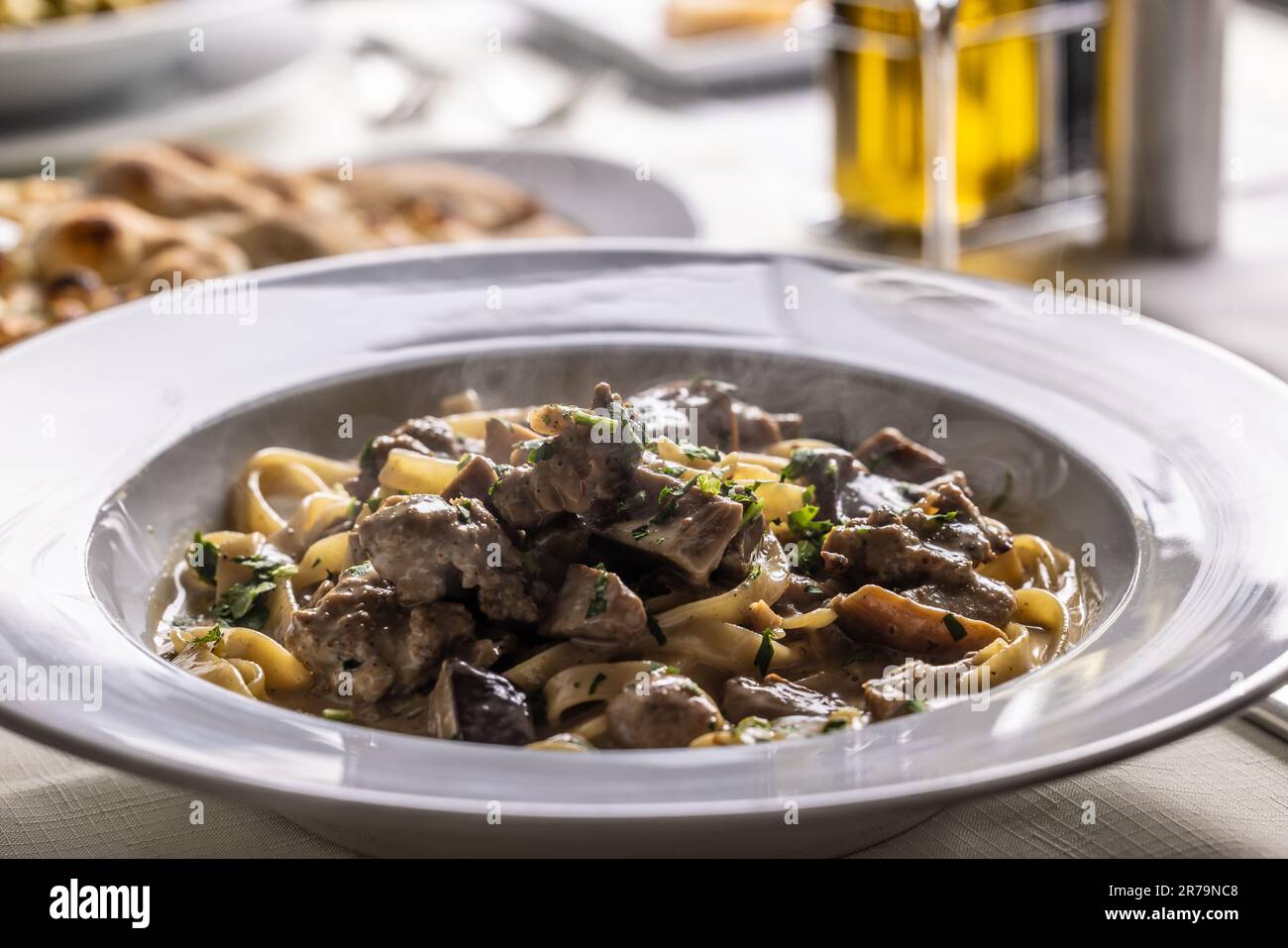 Tagliatelle con salsiccia e porcini, pasta italiana con salsiccia e funghi estivi cep. Foto Stock