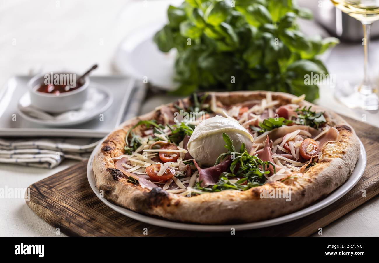 Pizza appena sfornata con prosciutto, rucola e mozzarella di bufala. Foto Stock