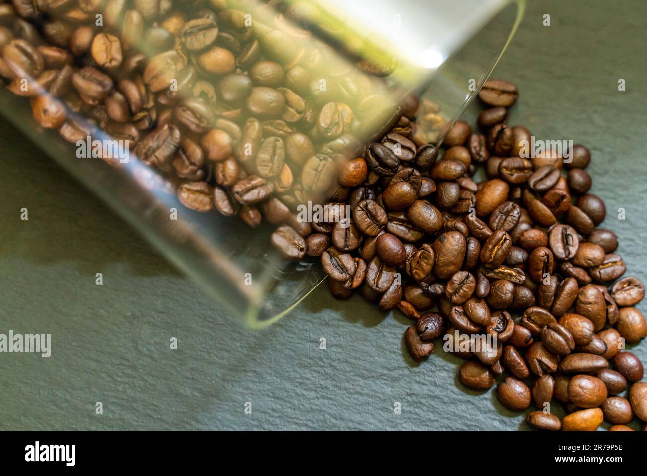 recipiente del caffè che fuoriesce dallo sfondo dei chicchi di caffè Foto Stock
