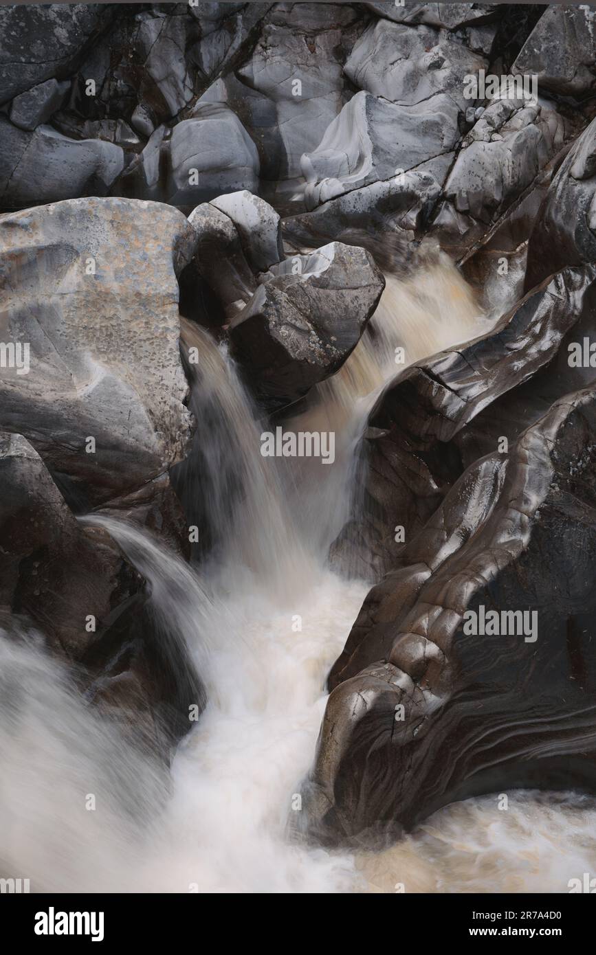 Un colpo verticale del fiume Garry che scorre attraverso grandi pietre in una foresta in Highland Perthshire Foto Stock