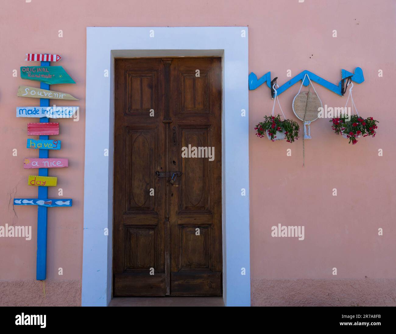 Vecchia porta in legno con bella decorazione su una facciata casa rosa Foto Stock