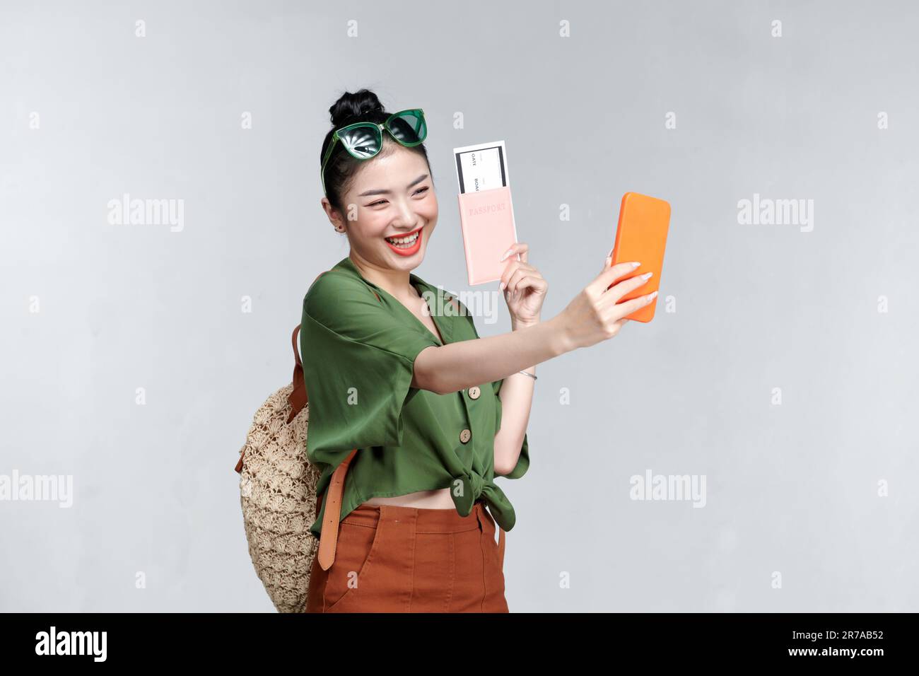 Felice viaggiatore donna con passaporto e biglietti d'imbarco prendere un selfie da smartphone Foto Stock