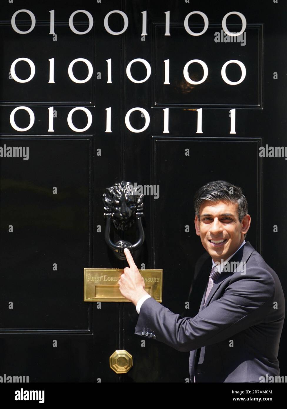 Il primo ministro Rishi Sunak si trova all'ingresso di 10 Downing Street, Londra, mentre i numeri attaccati alla porta spiegano la "London Tech Week" in codice binario, davanti a un ricevimento in giardino per la London Tech Week. Il codice binario è una forma di linguaggio di codifica che utilizza solo due simboli, '0' e '1', per trasmettere e memorizzare le informazioni. Data immagine: Mercoledì 14 giugno 2023. Foto Stock