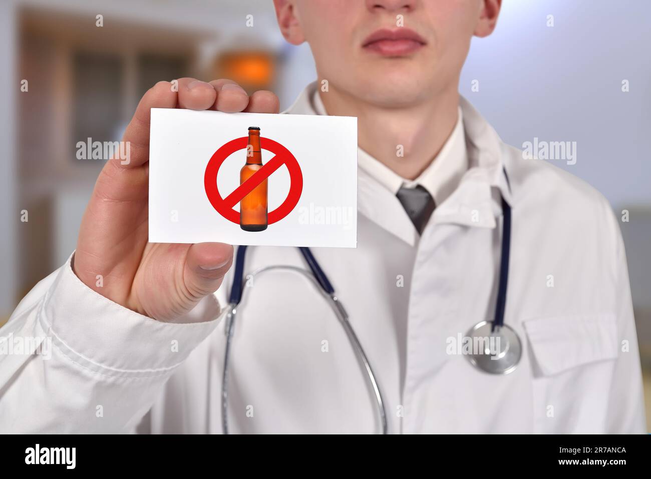 dottore in possesso di una tessera visita con simbolo di stop alcolico Foto Stock