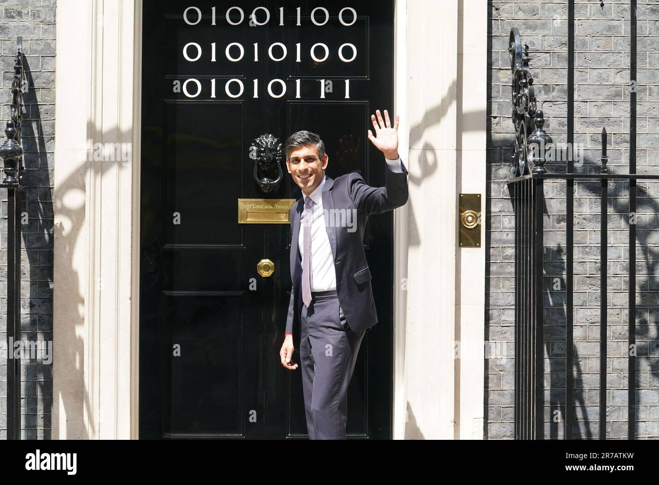 Il primo ministro Rishi Sunak si trova all'ingresso di 10 Downing Street, Londra, mentre i numeri attaccati alla porta spiegano la "London Tech Week" in codice binario, davanti a un ricevimento in giardino per la London Tech Week. Il codice binario è una forma di linguaggio di codifica che utilizza solo due simboli, '0' e '1', per trasmettere e memorizzare le informazioni. Data immagine: Mercoledì 14 giugno 2023. Foto Stock
