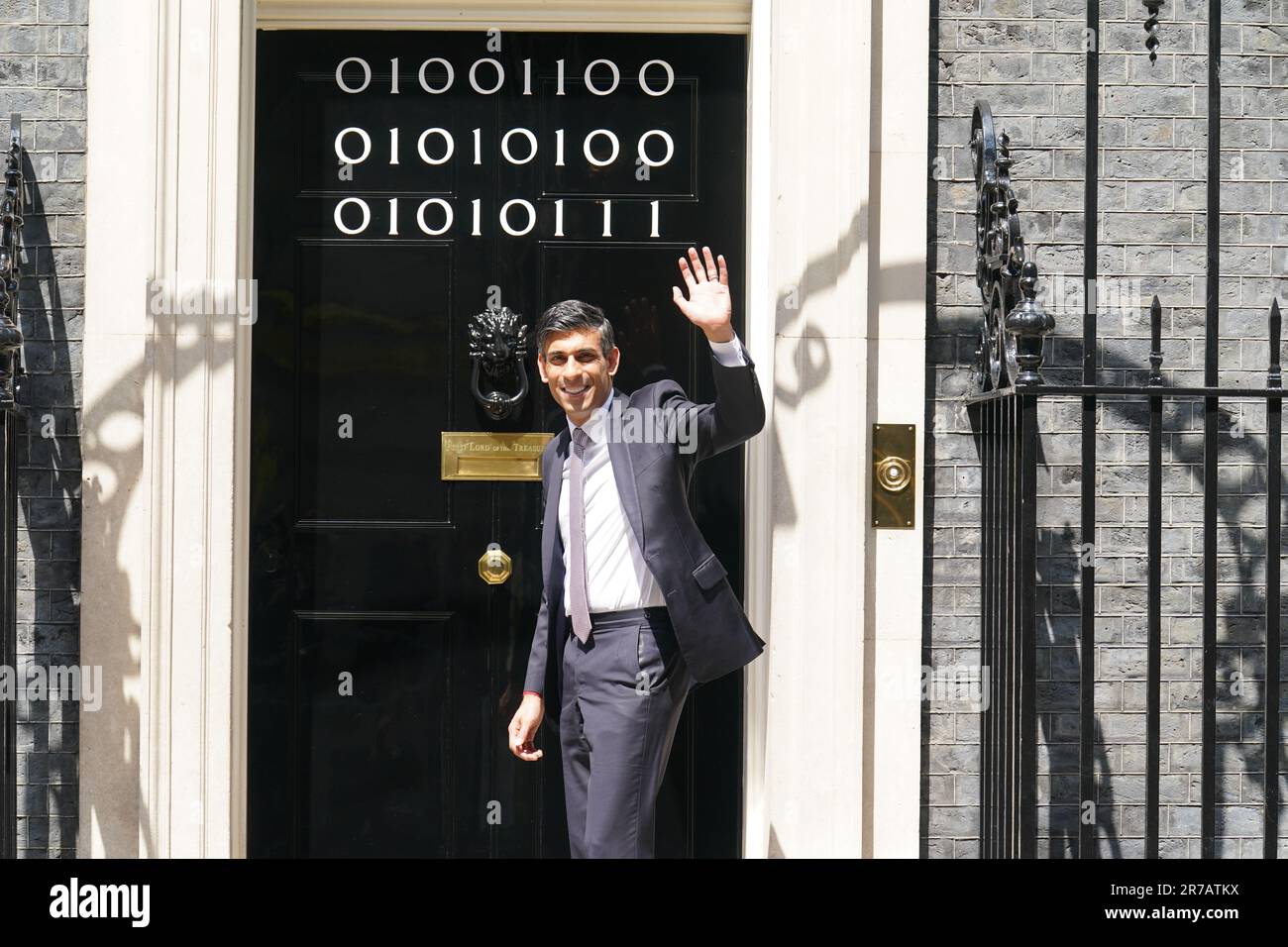 Il primo ministro Rishi Sunak si trova all'ingresso di 10 Downing Street, Londra, mentre i numeri attaccati alla porta spiegano la "London Tech Week" in codice binario, davanti a un ricevimento in giardino per la London Tech Week. Il codice binario è una forma di linguaggio di codifica che utilizza solo due simboli, '0' e '1', per trasmettere e memorizzare le informazioni. Data immagine: Mercoledì 14 giugno 2023. Foto Stock