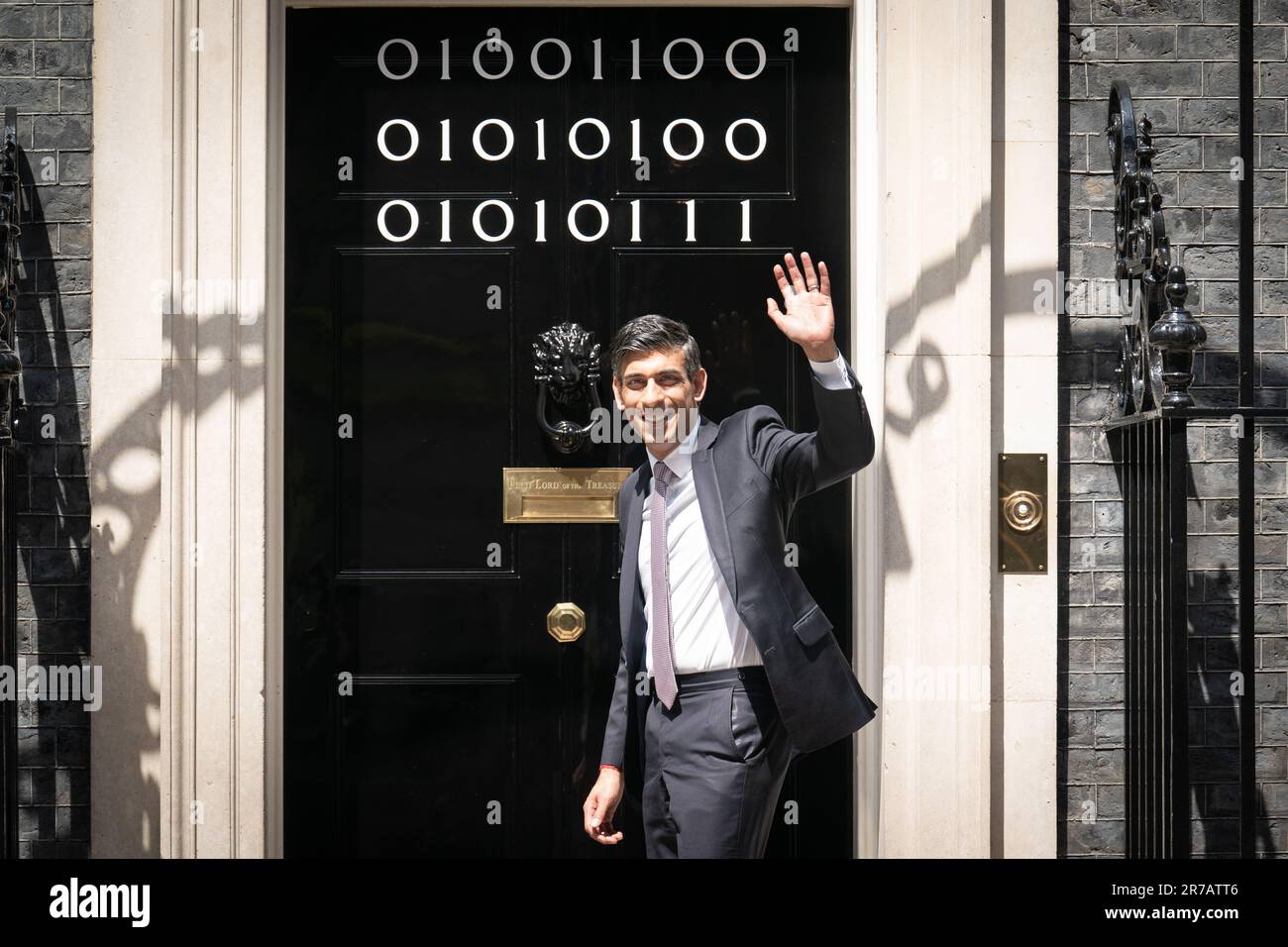Il primo ministro Rishi Sunak si trova all'ingresso di 10 Downing Street, Londra, mentre i numeri attaccati alla porta spiegano la "London Tech Week" in codice binario, davanti a un ricevimento in giardino per la London Tech Week. Il codice binario è una forma di linguaggio di codifica che utilizza solo due simboli, '0' e '1', per trasmettere e memorizzare le informazioni. Data immagine: Mercoledì 14 giugno 2023. Foto Stock