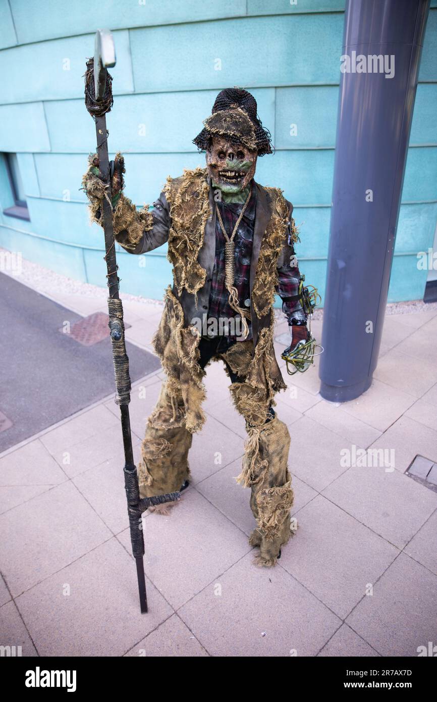 HARROGATE, REGNO UNITO - 3 GIUGNO 2023. Un cosplayer maschile vestito come spaventoso spaventoso scarabeo o creatura su palafitte con un synhe in un comico britannico Foto Stock