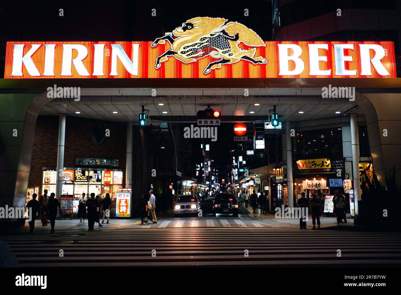 Una vivace scena di strada di notte a Hiroshima, Giappone, con distributori automatici e cartelli illuminati Foto Stock