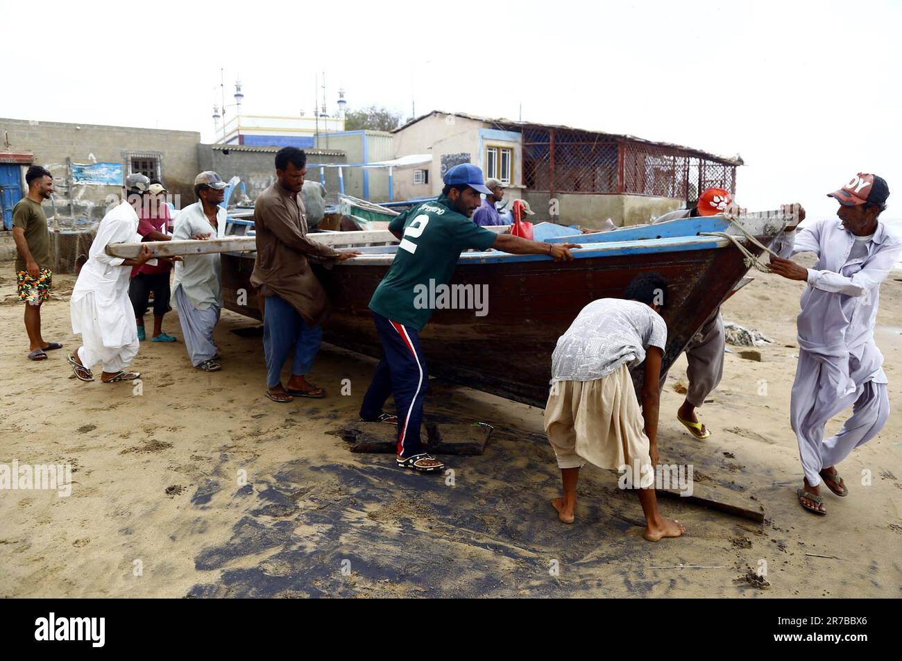 Karachi, Pakistan, 14/06/2023, i pescatori sono occupati nel spostare le loro barche dal mare poichè le attività costiere sono state vietate davanti alla tempesta ciclonica Biparjoy, ad al Rehman Goth a Karachi mercoledì 14 giugno 2023. Il dipartimento meteorologico pakistano il mercoledì previsione pioggia con tuono e forte polvere-tempesta a Karachi questo pomeriggio o sera sotto gli effetti del ciclone tropicale Biparjoy che si sta avvicinando alla costa. Foto Stock