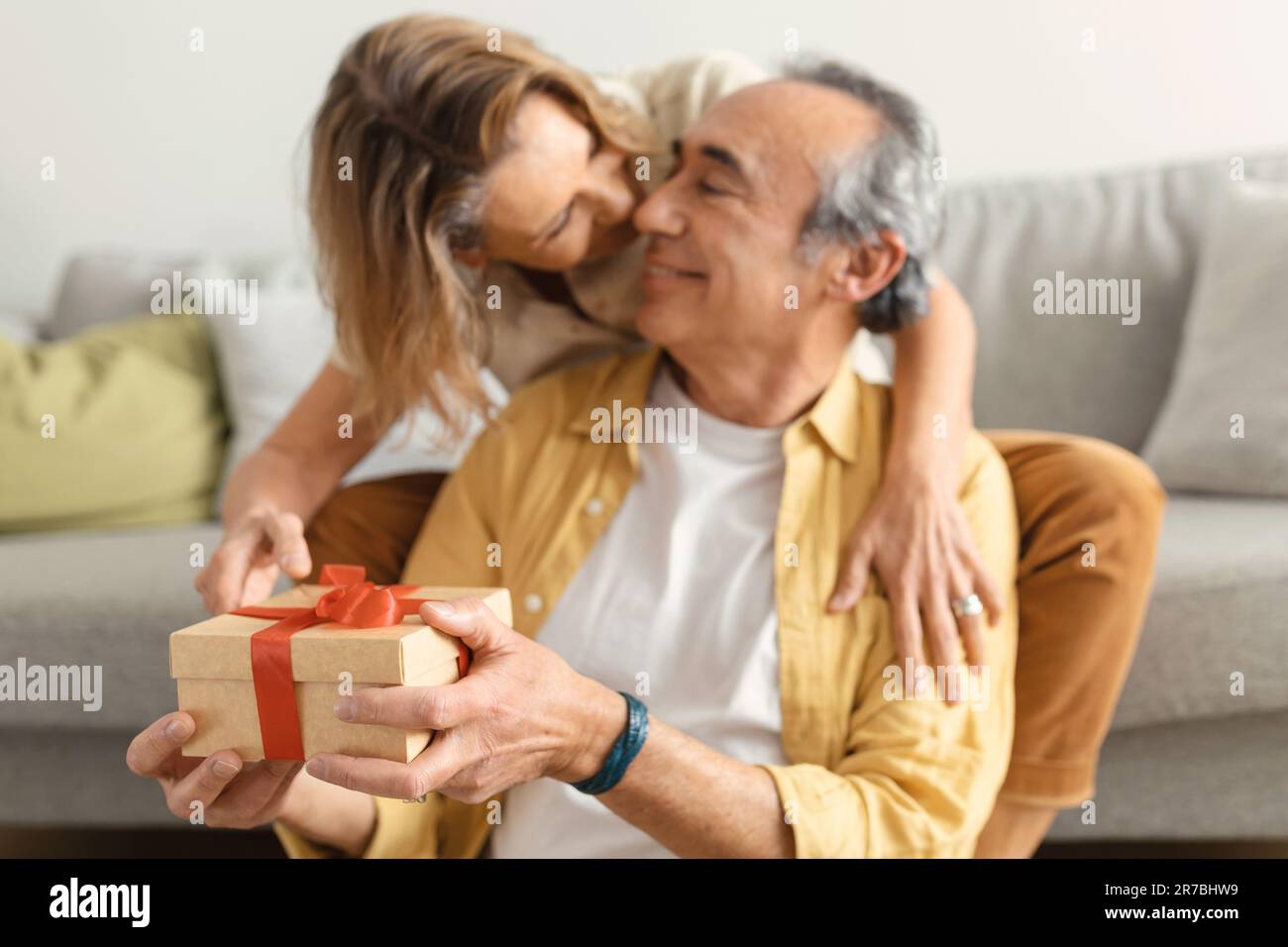 Amante moglie anziana che dà la scatola regalo di compleanno a marito  felice e baciare l'uomo in guancia, fuoco selettivo sul presente Foto stock  - Alamy
