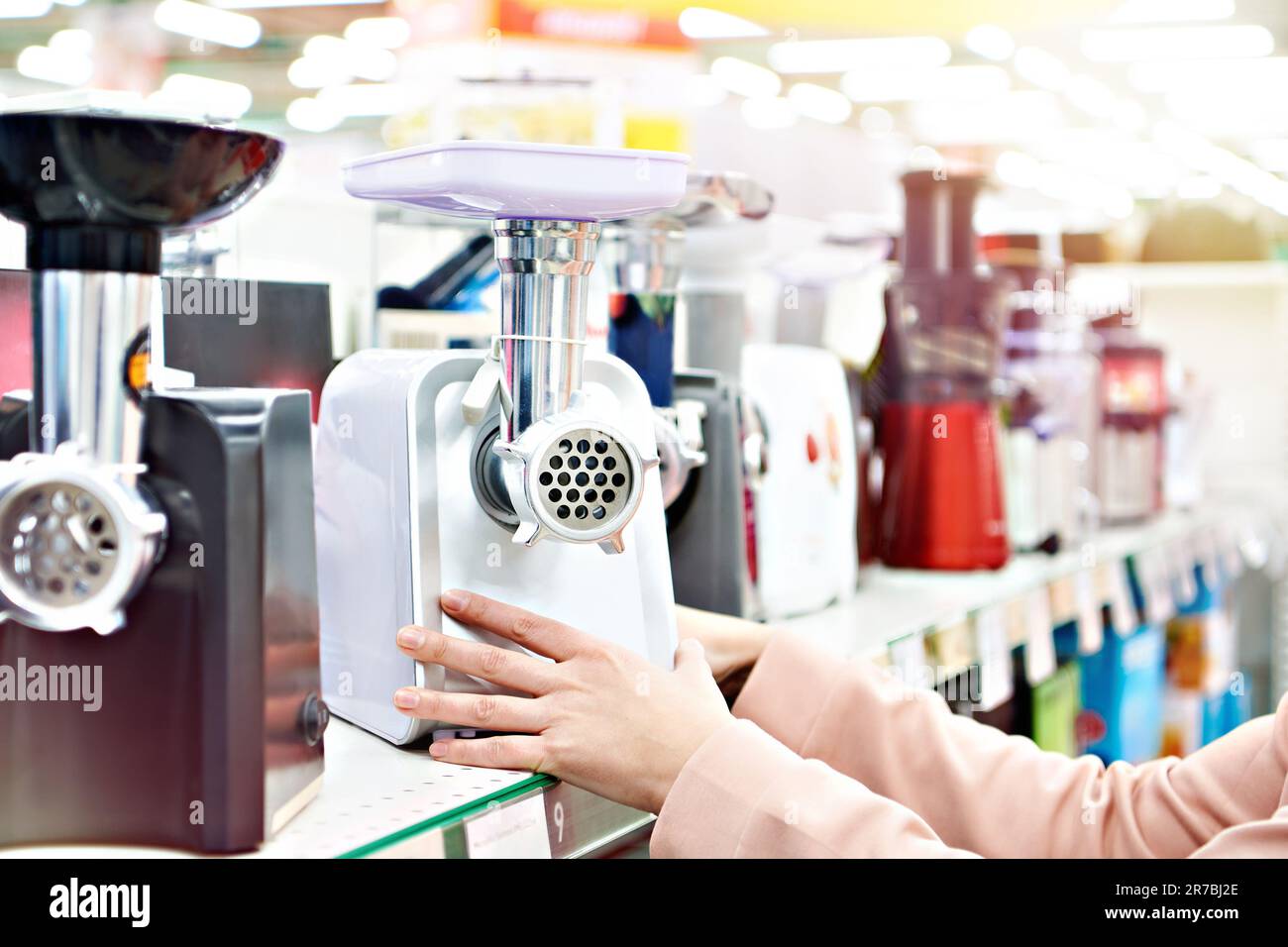 Tritacarne elettrico nella mano dell'acquirente nel negozio Foto Stock