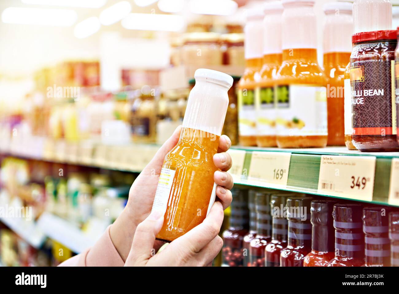 Salsa culinaria nella mano del compratore nel deposito Foto Stock