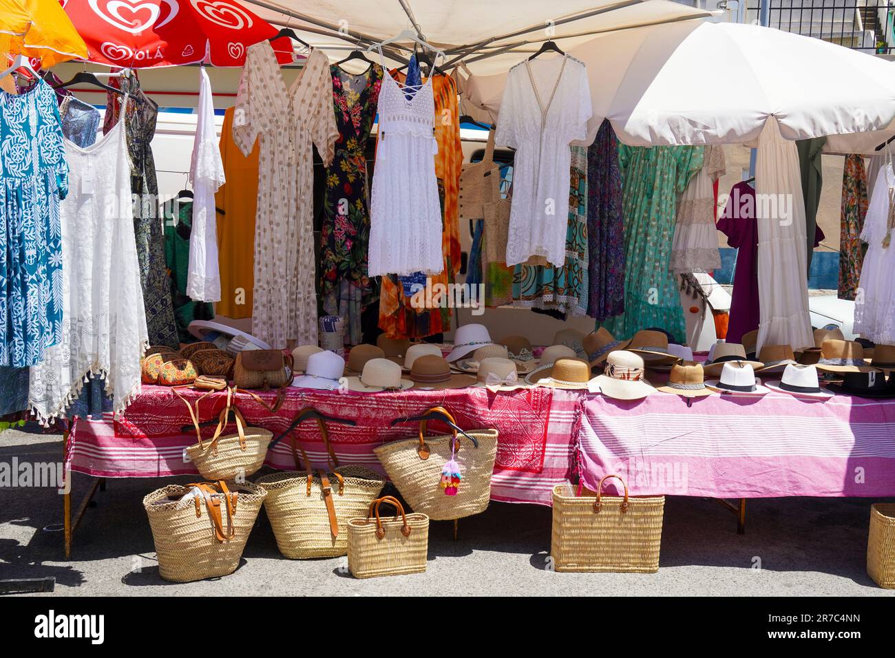 Stand al mercato locale in Avenue Infante de Sagres, Quarteira, Algarve, Portogallo che vende abbigliamento, cappelli e borse. Foto Stock