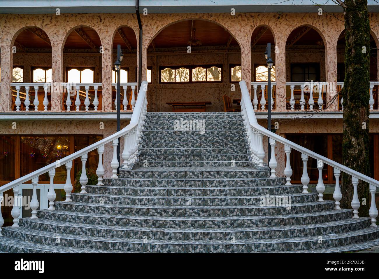 Una scala in marmo verde, ringhiere e balaustre che conduce ad un edificio con archi semicircolari Foto Stock