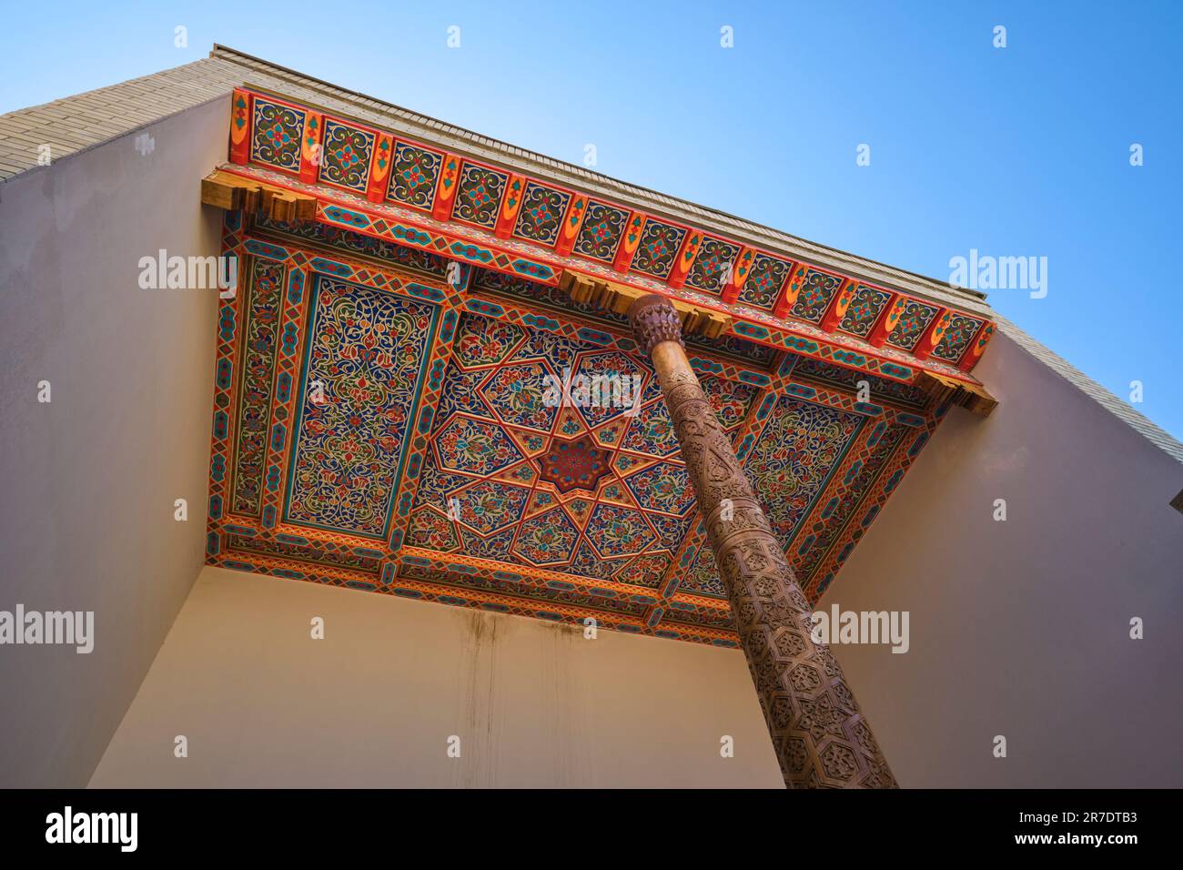 Vista dell'elaborato e colorato dipinto di un soffitto in legno intagliato in un portico tradizionale. Nell'era ricreata, Silk Road guardando villaggio di Anhor p Foto Stock