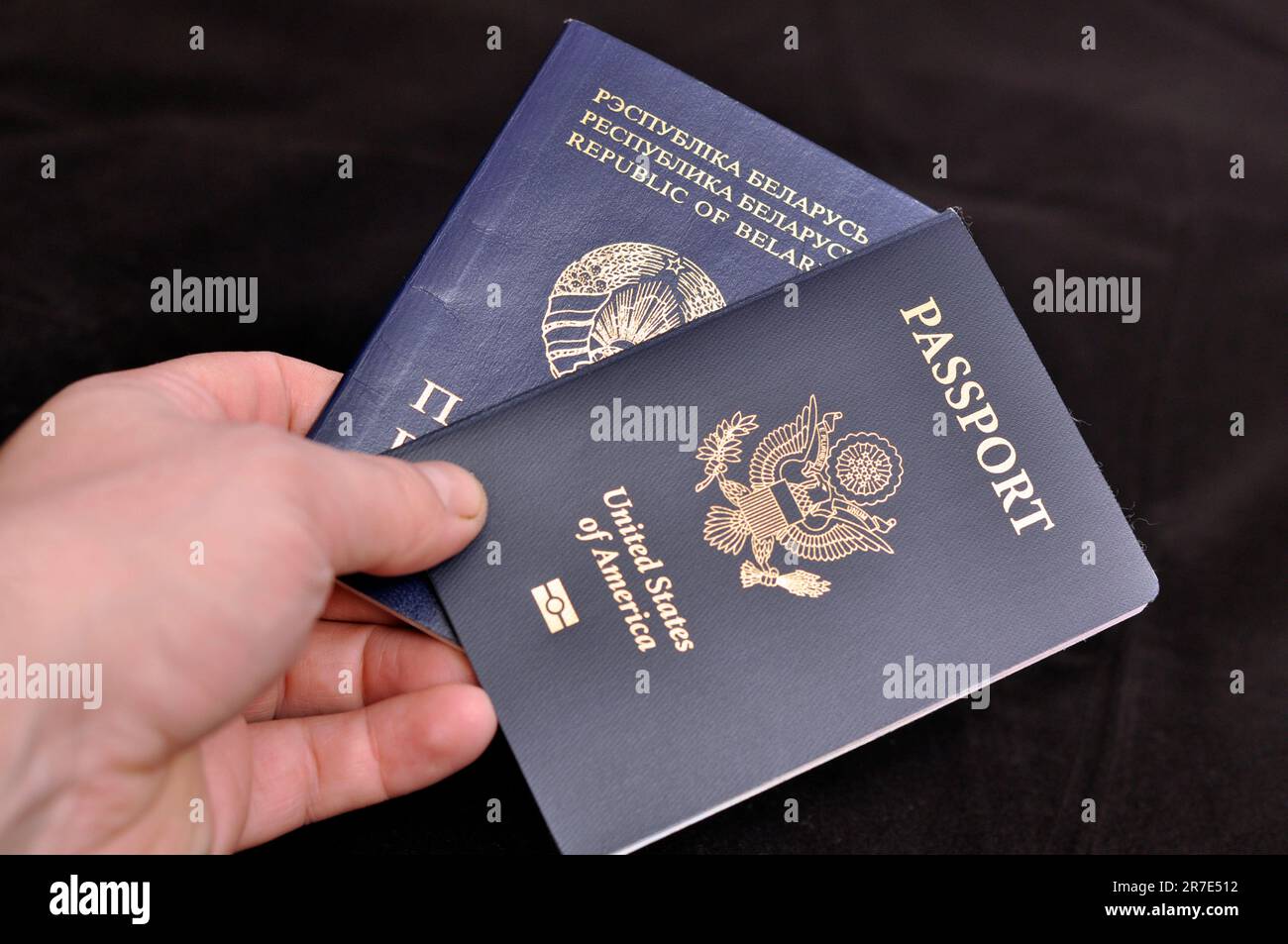 Mano con passaporto di un cittadino degli Stati Uniti e della Bielorussia. Doppia cittadinanza. Identificazione. Foto Stock