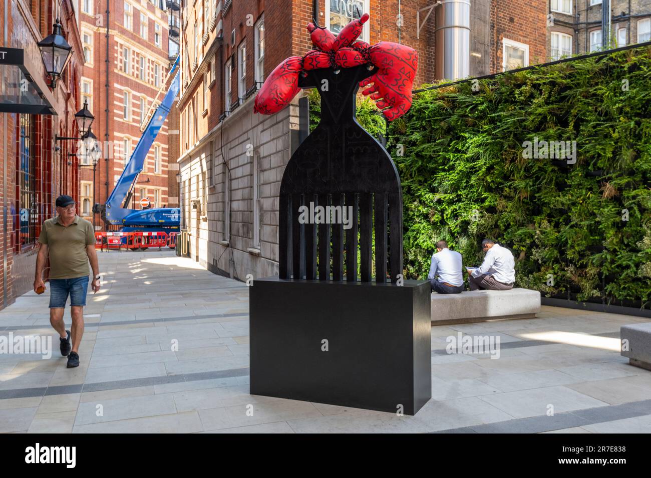 Londra, Regno Unito. 15 giugno 2023. Un uomo passa 'Detangling MBS' di Josephine Chime a Hoopers Court, Knightsbridge in anteprima dell'annuale Public Art Trail di Kensington and Chelsea Art Week (KCAW), che presenta sculture, installazioni e murales di livello mondiale esposti in tutto il quartiere dal 22 giugno al 31 agosto. Credit: Stephen Chung / Alamy Live News Foto Stock