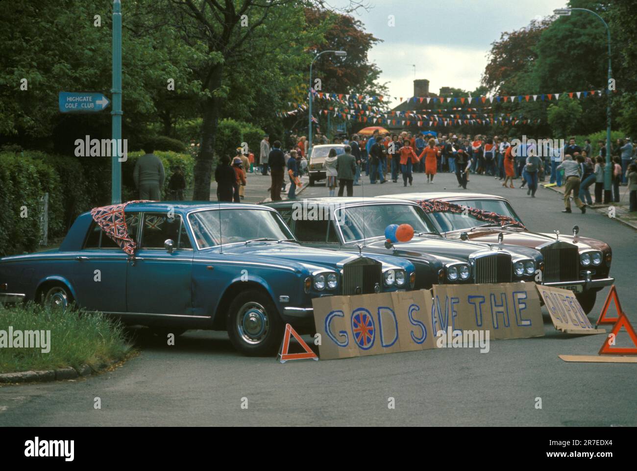 Dio Salva la Regina. Celebrazione del Giubileo d'Argento della Regina Elisabetta II 1977. Tre Rolls Royces di colore blu, bianco, ben grigio e una sorta di rosso, blocco della strada, un segno scritto su scatole di cartone recita "Dio salvare la Regina". Hampstead, nord di Londra, Inghilterra circa 1977 giugno. 1970S REGNO UNITO HOMER SYKES Foto Stock