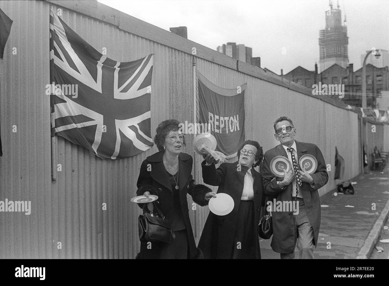 Celebrazione del Giubileo d'Argento della Regina Elisabetta II 1977. Repton Street, la festa di strada è finita, ma non è stata chiarita e alcuni straglers si riuniscono per una canzone. Whitechapel, Tower Hamlets, East London, Inghilterra circa giugno 1977. Foto Stock