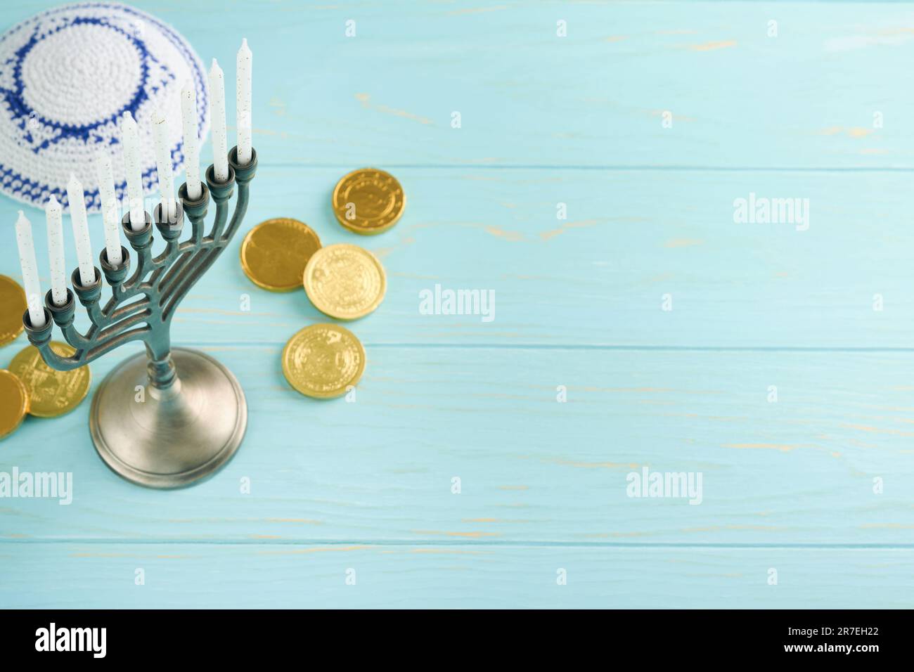 Hanukkah felice. Hanukkah vecchio Menorah sullo sfondo della bandiera israeliana con luce solare o bokeh su sfondo di legno bianco. Immagine religiosa dei gioielli Foto Stock