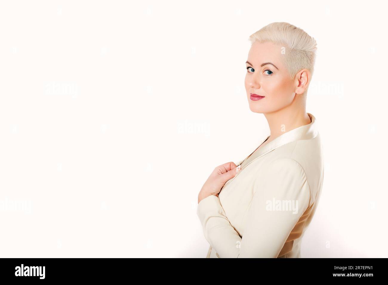 Studio ritratto di bella donna matura su sfondo bianco, guardando sopra la spalla, indossando giacca, taglio corto Foto Stock