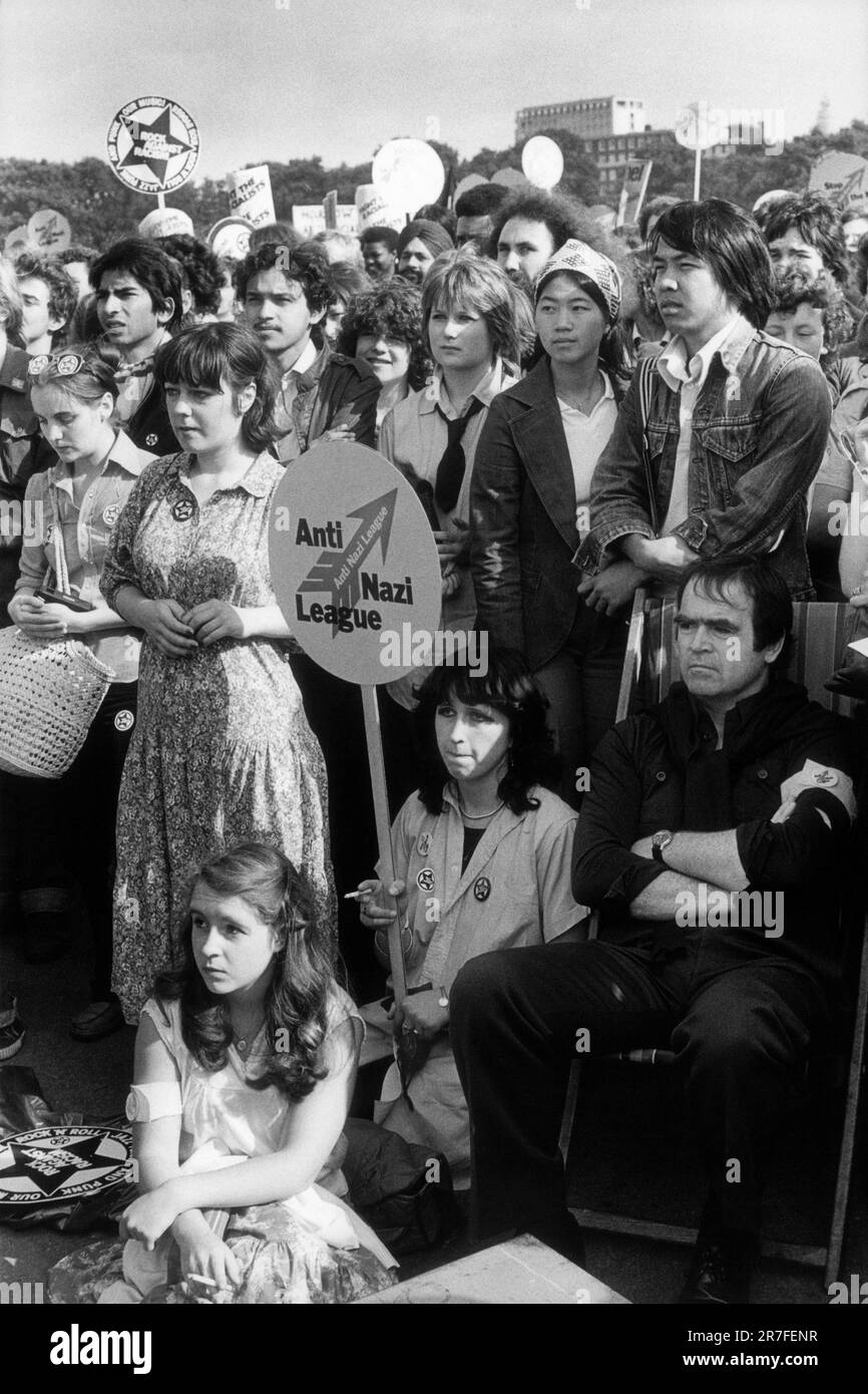 Rock Against Racism 1970s Londra, Inghilterra circa 1978. Rock Against Racism rally Hyde Park. Le folle si riuniscono per ascoltare gli oratori, una giovane donna tiene una bandiera Anti nazista League. 70S REGNO UNITO HOMER SYKES Foto Stock