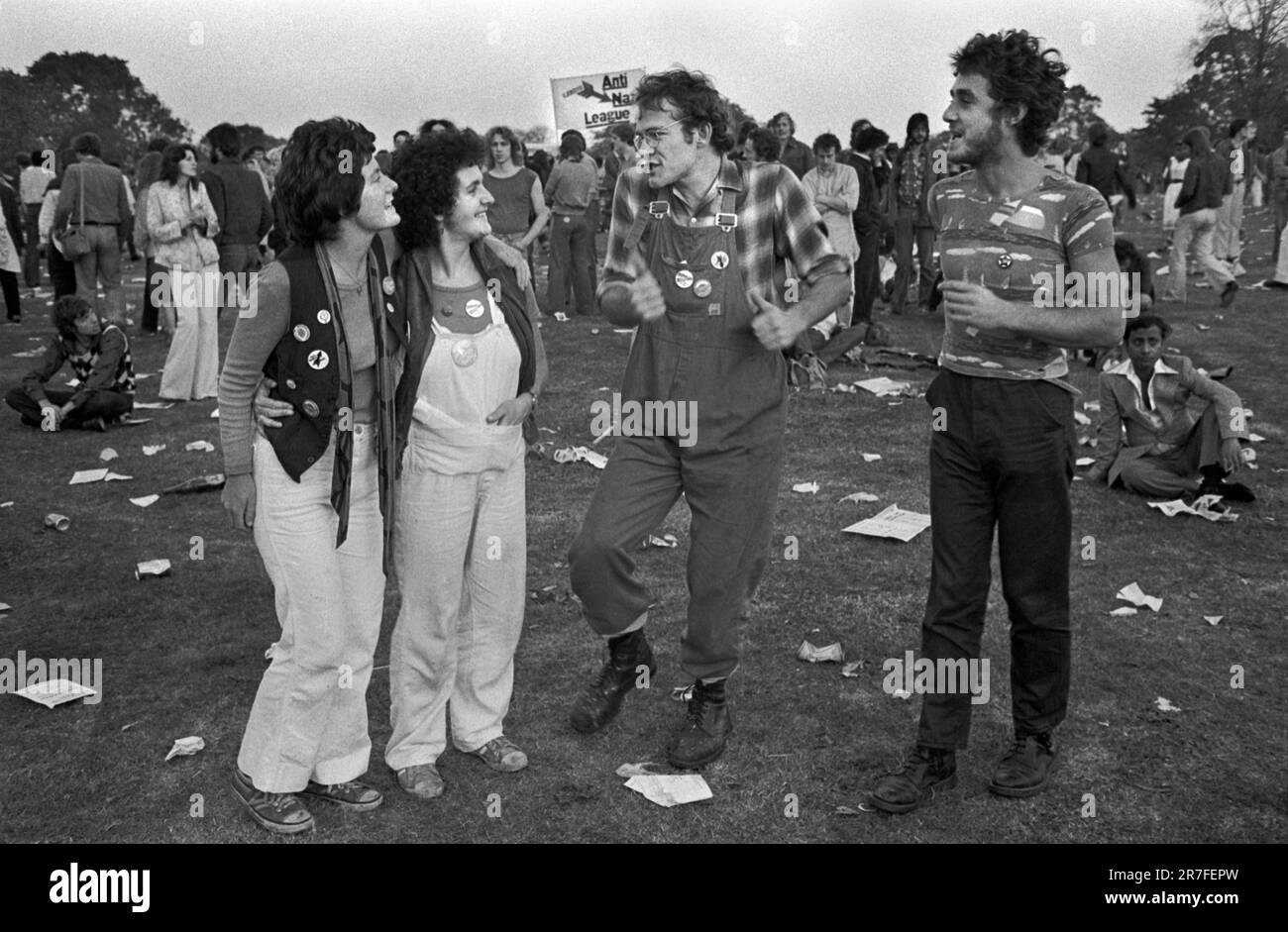 1970s Fashion UK, un gruppo di giovani adulti che indossano salopette alla moda ricoperte di spille con bottoni a spillo che chiacchierano e ascoltano la musica a Brockwell Park, al Rock Against Racism March and Concert. Marciarono da Hyde Park a Brockwell Park vicino a Brixton. Brockwell, South London, Inghilterra 1978. HOMER SYKES Foto Stock