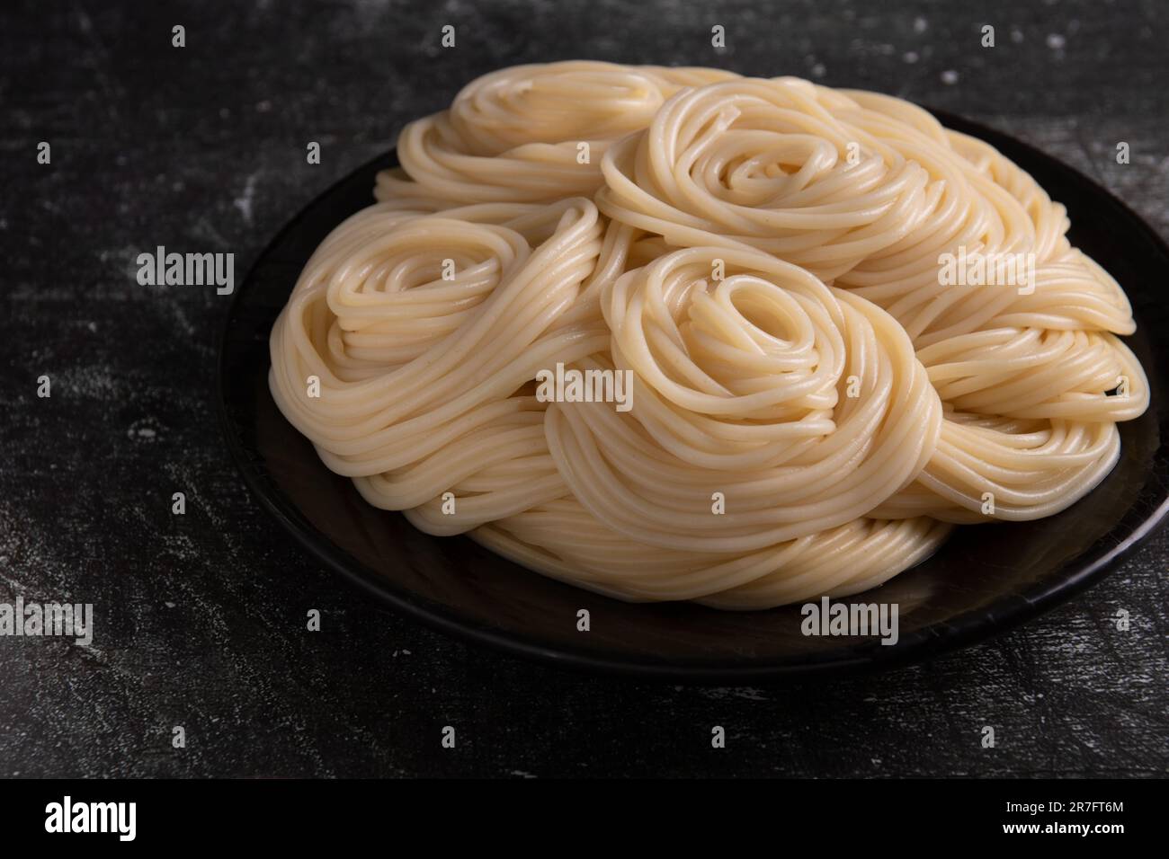 foto della pasta giacente in un piatto di colore scuro Foto Stock