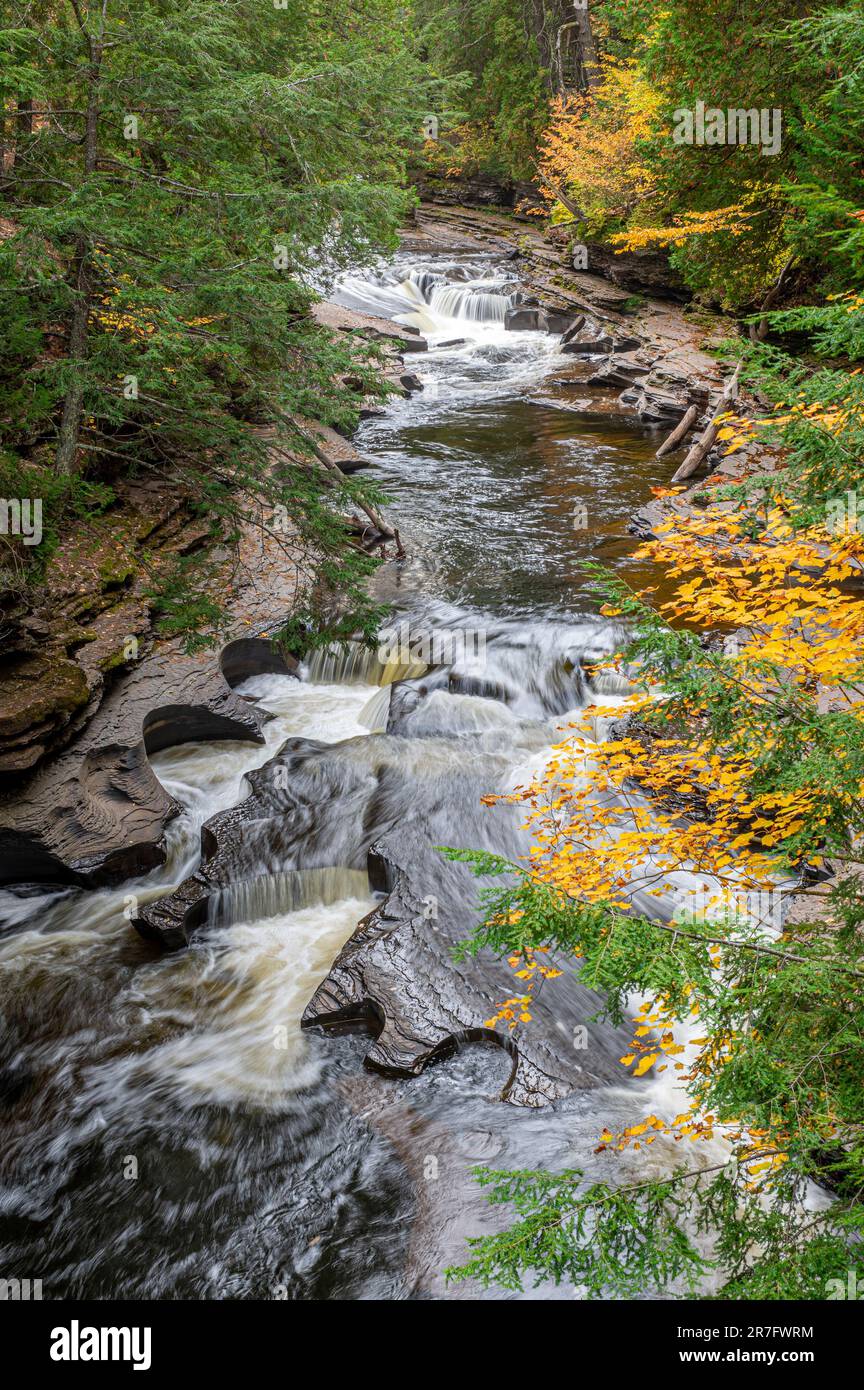 Il fiume Presque Isle della penisola superiore del Michigan è un paese delle meraviglie d'autunno tra il fogliame mutevole e le numerose cascate e il rame c Foto Stock