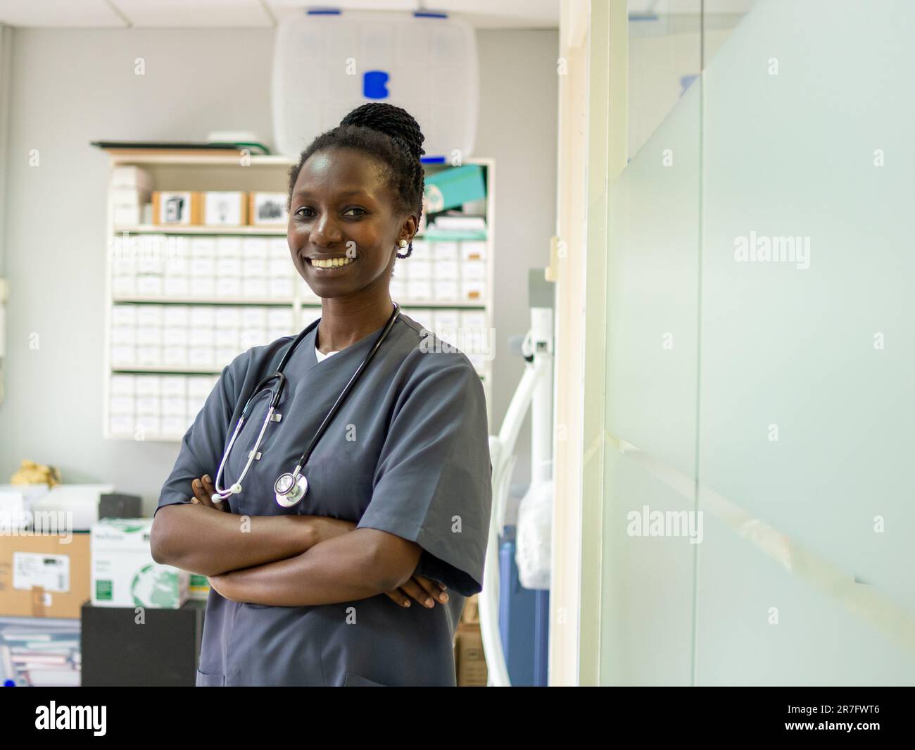 Giovane ufficiale medico in piedi con il suo stetoscopio nel suo ufficio Foto Stock