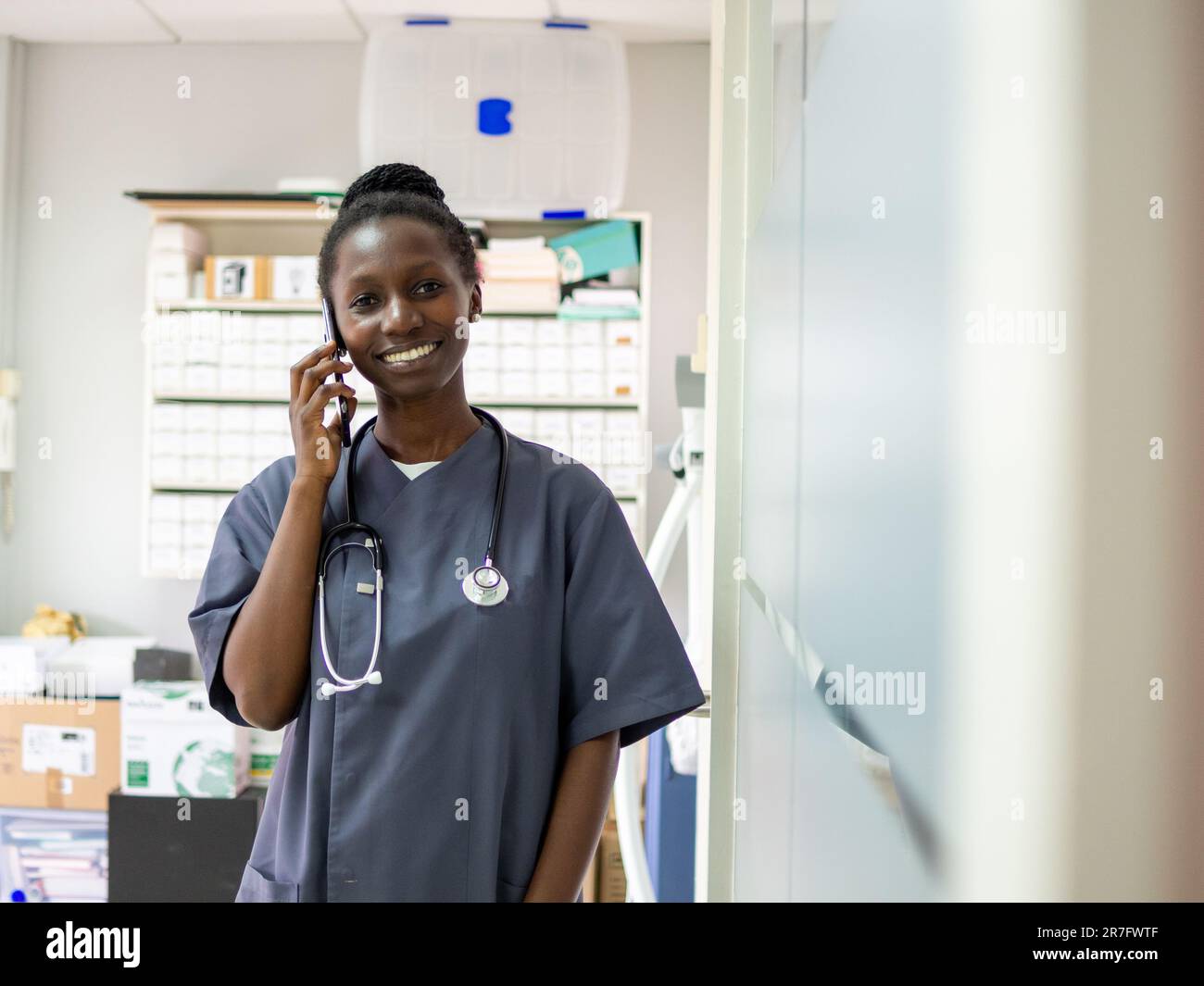 Giovane ufficiale medico in piedi con il suo stetoscopio nel suo ufficio Foto Stock