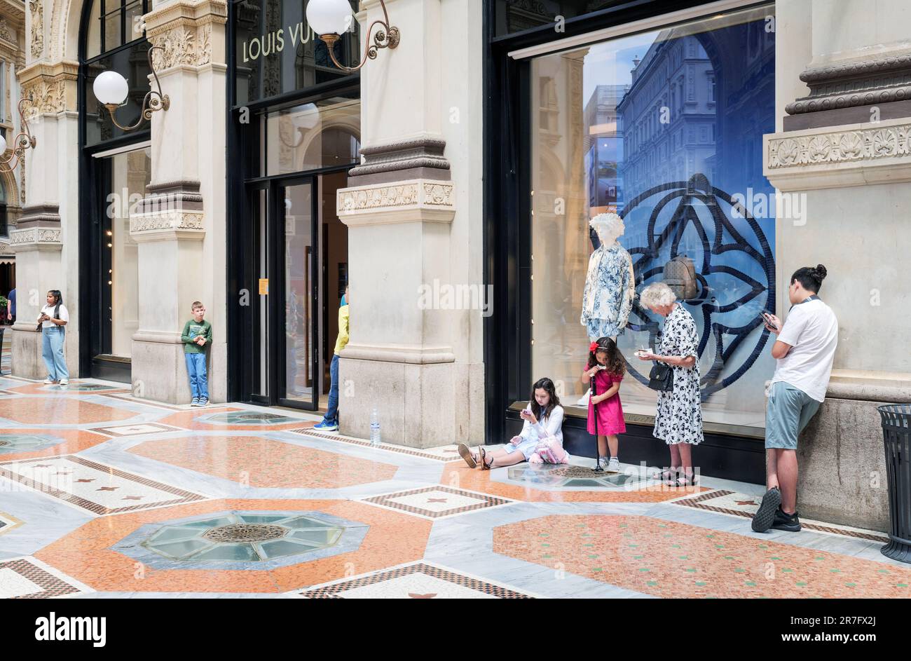 Negozio Louis Vuitton in Galleria Vittorio Emanuele Milano, Italia. Le persone si divertono a rimanere vicino a marchi iconici. Foto Stock