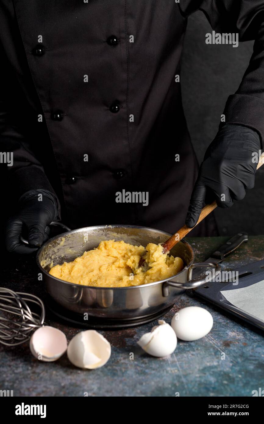 Preparazione di pasta pasticcera per profiteroles, eclairs. Il processo di fare profiteroles Foto Stock