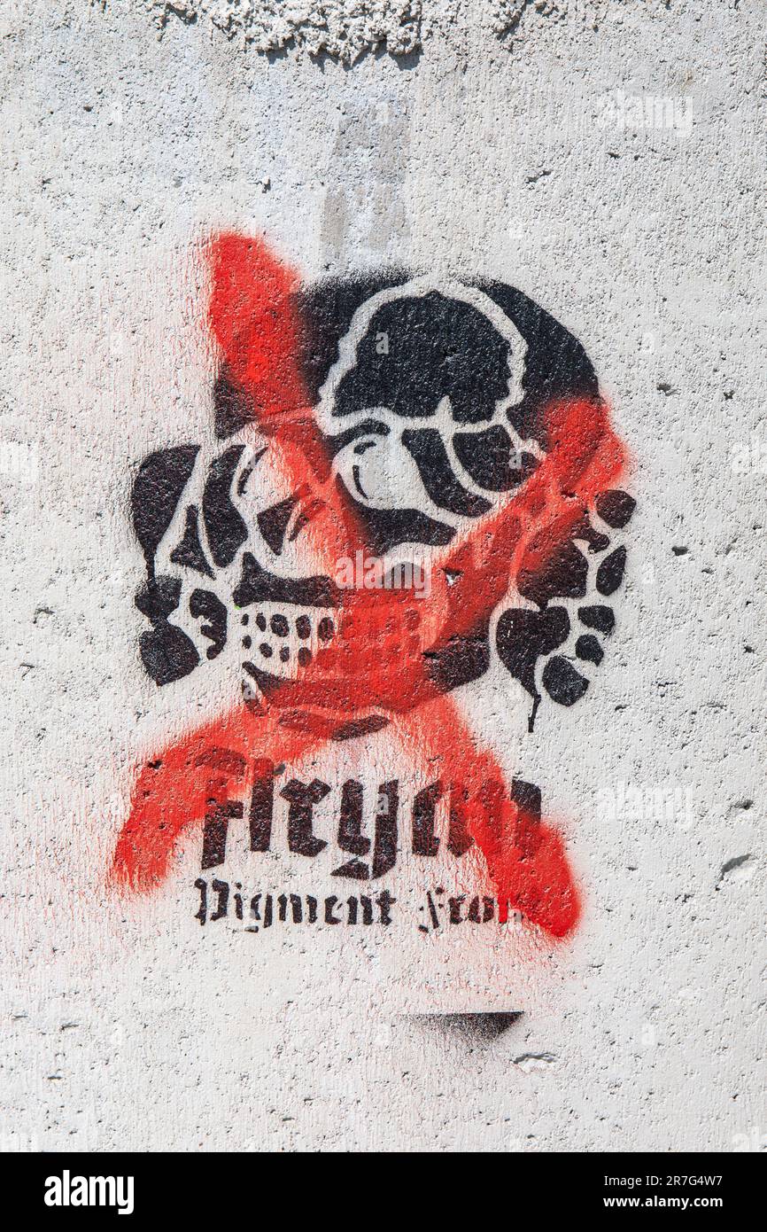 Croce rossa sul pigmento aryan Graffiti stencil frontale su superficie in cemento nel distretto di Merihaka di Helsinki, Finlandia Foto Stock