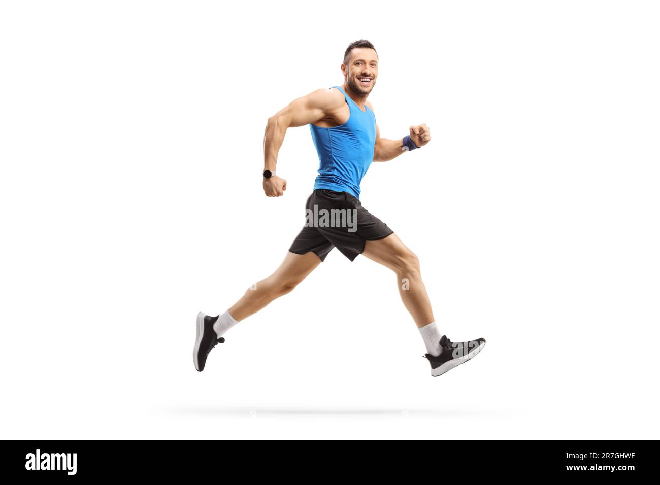 Profilo a tutta lunghezza di un uomo in corsa sportiva e sorridente isolato su sfondo bianco Foto Stock