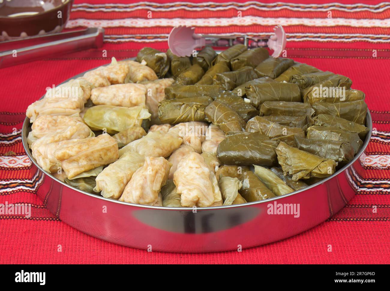 Cavolo ripieno e foglie di vite in offerta dello stand con piatti balcanici e bulgari. Foto Stock