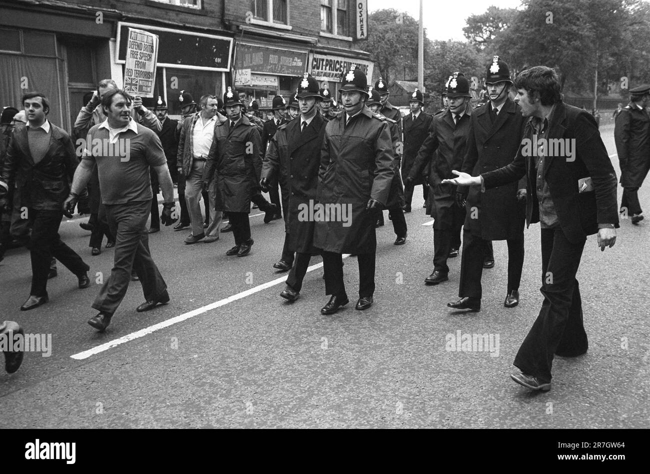 National Front marcia attraverso un sobborgo di Manchester, un dimostratore di sinistra harangues il NF che sono protetti dalla polizia. Manchester, Inghilterra, ottobre 8th 1977. 1970S REGNO UNITO HOMER SYKES Foto Stock