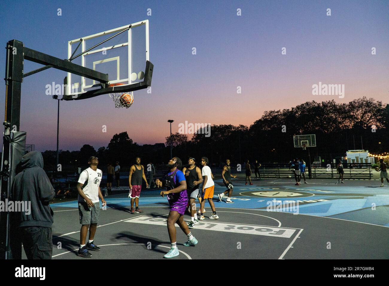 Meteo britannico, Clapham, Londra, 15 giugno 2023: In una leggera serata estiva dopo una giornata calda, i giocatori di basket si avvalgono dei campi illuminati di Clapham Common per esercitarsi. Credit: Anna Watson/Alamy Live News Foto Stock