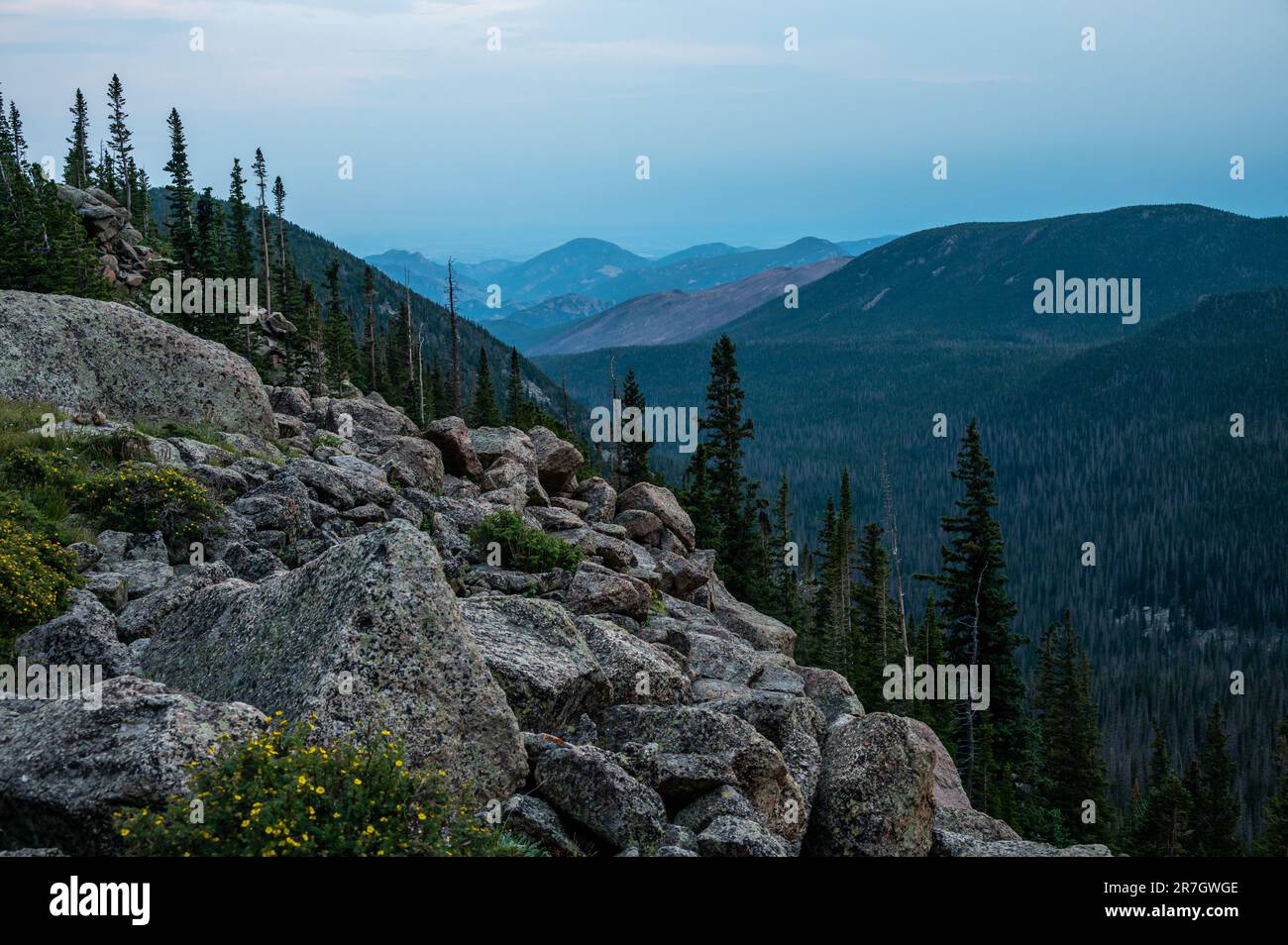 Il Granite Boulder Field si riversa sulla scogliera nella valle forestale, sotto lo Stormy Peaks Pass Foto Stock