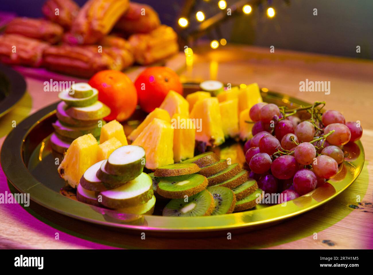 Vassoio di frutta con kiwi, arancia, ananas, uva e pera. Piatto colorato con allettanti fette di frutta. Foto Stock