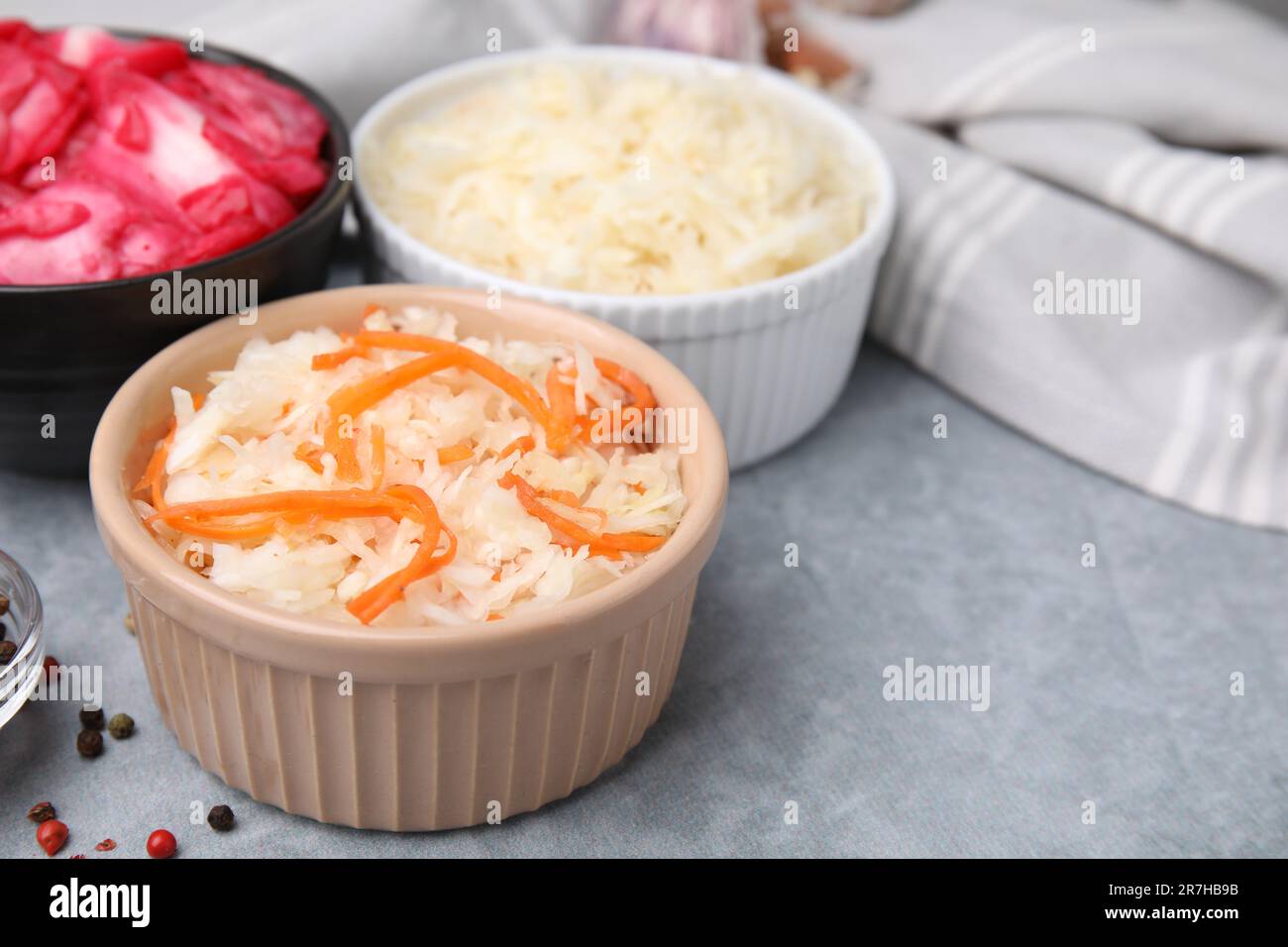 Deliziosi crauti preparati secondo diverse ricette su tavolo grigio chiaro, primo piano Foto Stock
