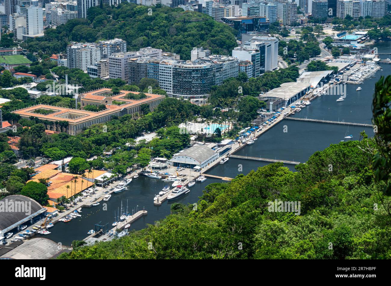 Vista aerea dei quartieri di Urca e Botafogo pieni di edifici e vegetazione verde, come si vede dalla piattaforma di osservazione della collina di Urca durante il soleggiato giorno estivo. Foto Stock