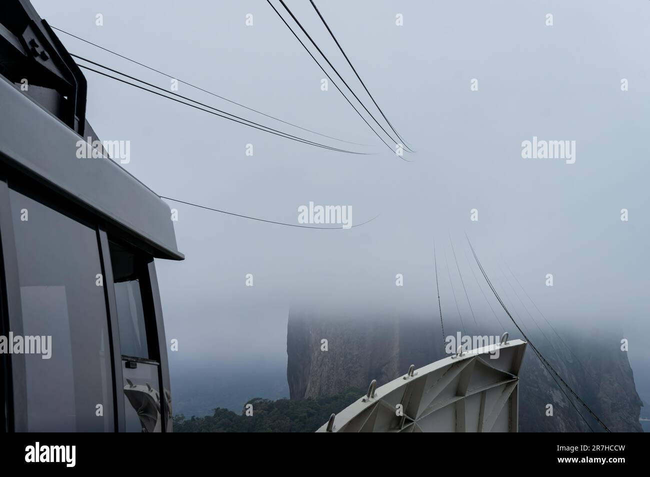 Sorreggi e tira i cavi della funivia Sugarloaf che scompaiono tra le nuvole spesse che passano come visto dalla stazione della funivia di Urca Hill in una giornata di sole. Foto Stock