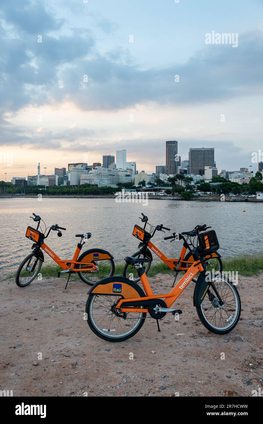 Alcune biciclette a noleggio Itau sono parcheggiate alla fine del Santos Dumont Rock Pier (Pier de Pedra) percorso sterrato nel quartiere Centro sotto il cielo estivo del tardo pomeriggio. Foto Stock