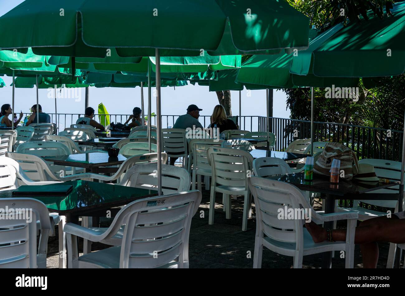 Tavoli all'aperto con ombrelloni verdi nell'area esterna del ristorante di montagna Corcovado nel quartiere di Santa Teresa sotto il sole del pomeriggio estivo. Foto Stock